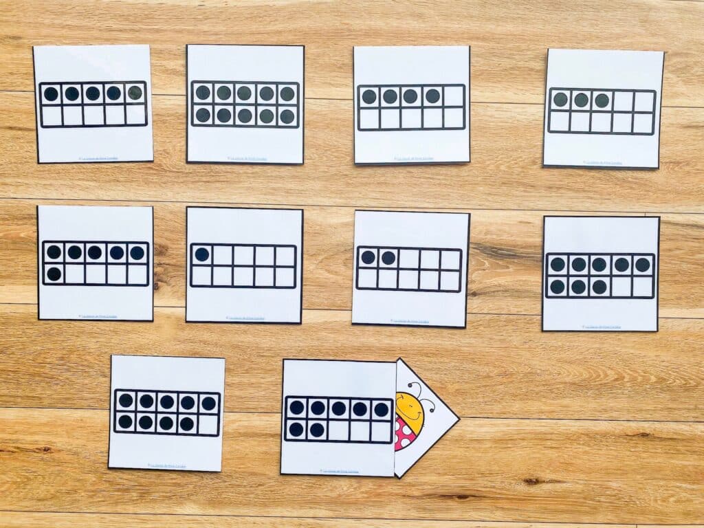 Showing the game bug under the rug being played. The bug is hidden under one of the numers. Students must count in French and find the bug.